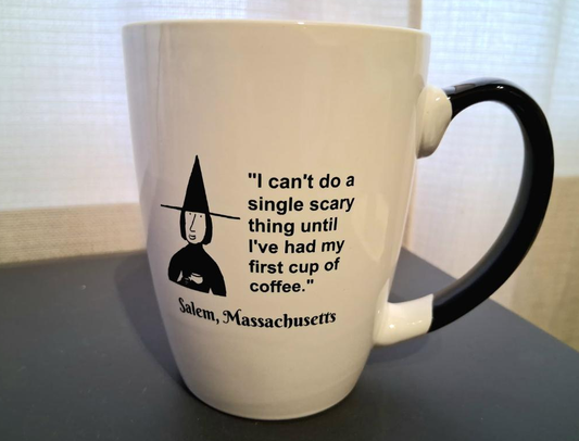 "I can't do a single scary thing until I've had my first cup of coffee." White, ceramic, 12 oz coffee mug with cobalt blue handle and interior.