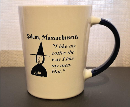 Salem, Massachusetts "I like my coffee the way I like my men. Hot." White, ceramic, 13 oz coffee mug with black handle and interior.