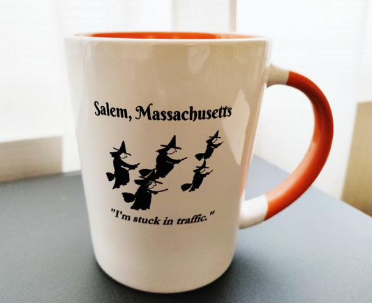 "I'm stuck in traffic." White, ceramic, 12oz coffee mug with orange handle and interior.